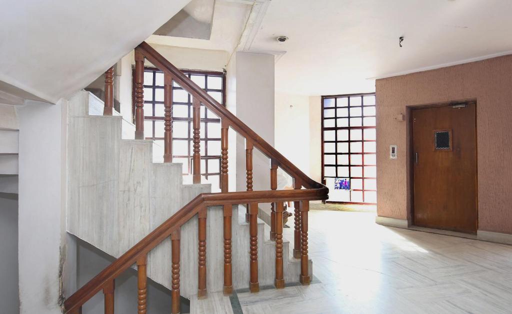 un escalier dans une maison avec une porte en bois dans l'établissement Capital O Kartik, à Jabalpur