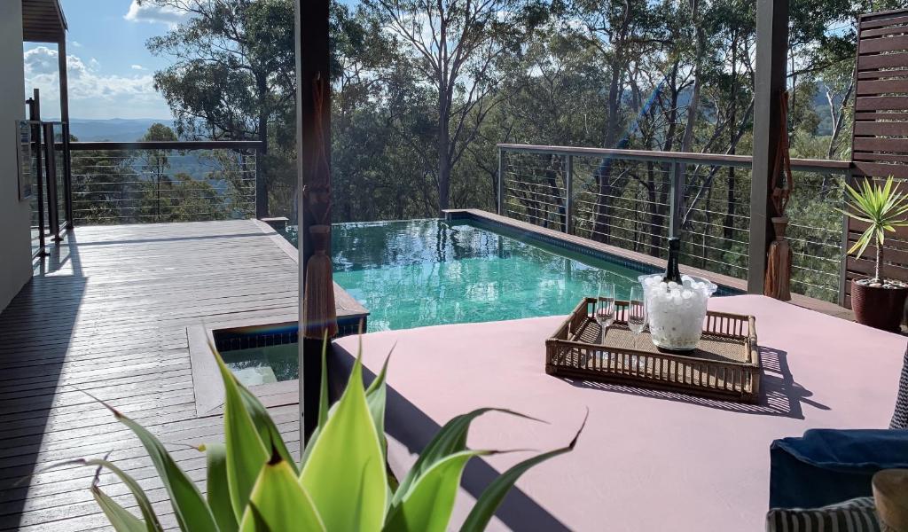 een terras met een zwembad en een tafel met een kaars bij Wild Edge Retreat in Wollombi