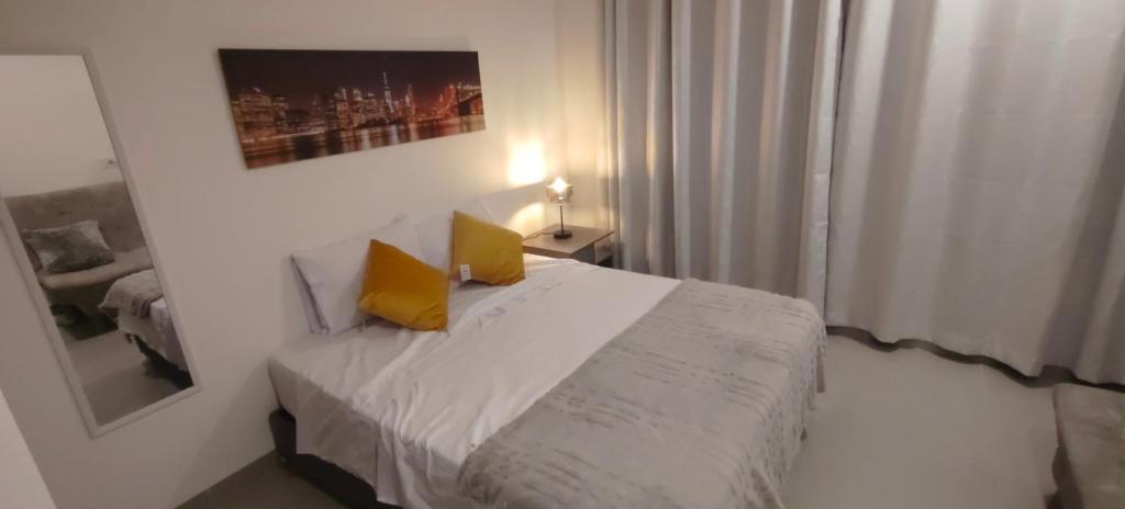 a bedroom with a bed with two yellow pillows on it at Santa marina in Santa Marta