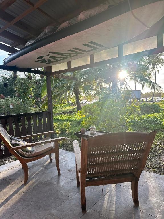 a patio with a table and a bench and a view at M&M moanatea lodge in Rangiroa