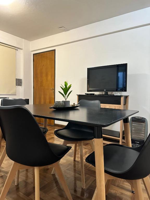 a dining room with a black table and chairs at Espacio necochea in Mendoza