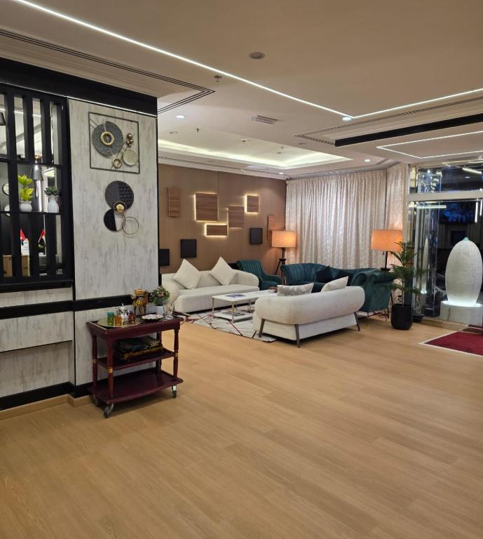 a large living room with couches and a table at Golden California Hotel in Dubai