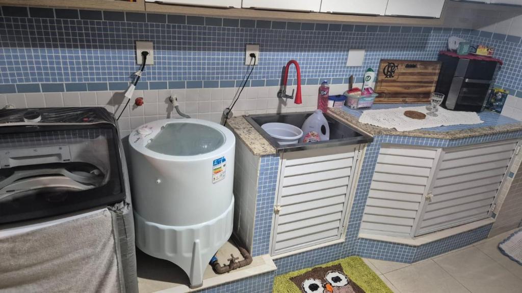 eine Küche mit Spüle und Waschmaschine in der Unterkunft Casa completa a 10min da praia de BC in Balneário Camboriú