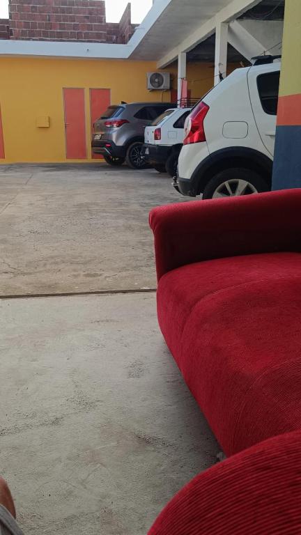 a red couch sitting in a parking lot at Pousada voo livre in Serra Talhada