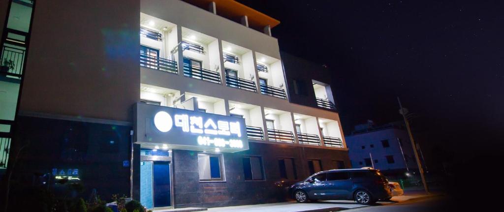 a van parked in front of a building at night at Daecheon Story Pension in Boryeong