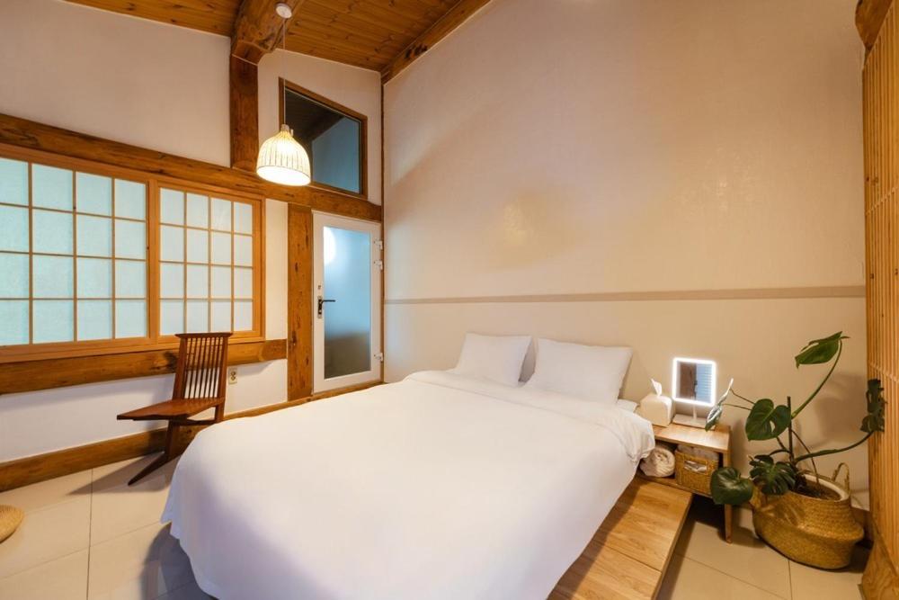 a bedroom with a large white bed and windows at Yangpyeong Evergrove in Yangpyeong