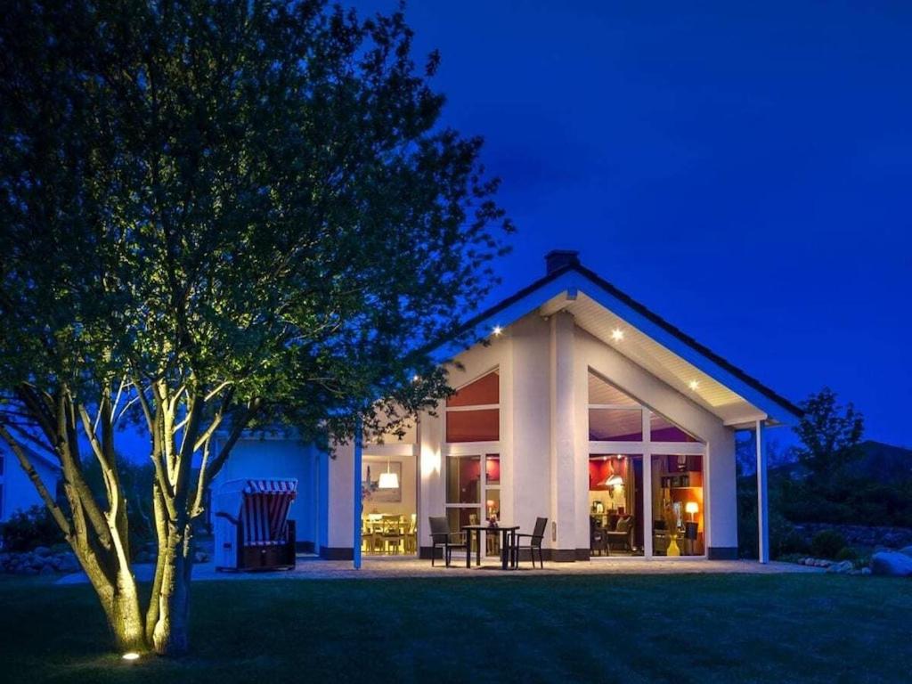 ein Haus mit einem Baum im Garten nachts in der Unterkunft Seepark - Holiday Home - Rügen in Vaschvitz