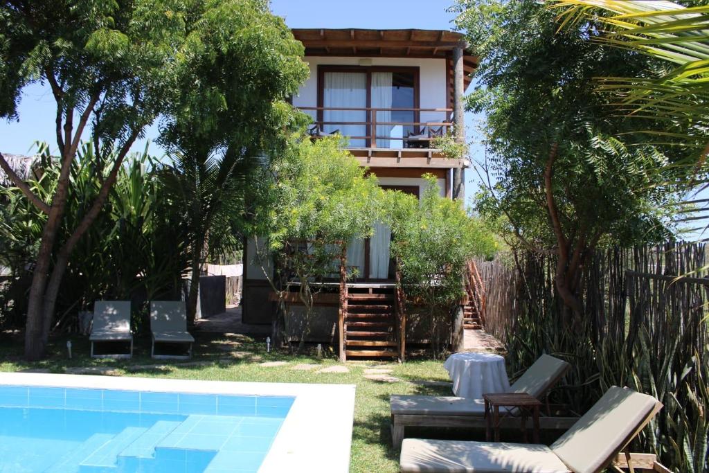 een villa met een zwembad en een huis bij Mallki bungalows with pool in Vichayito