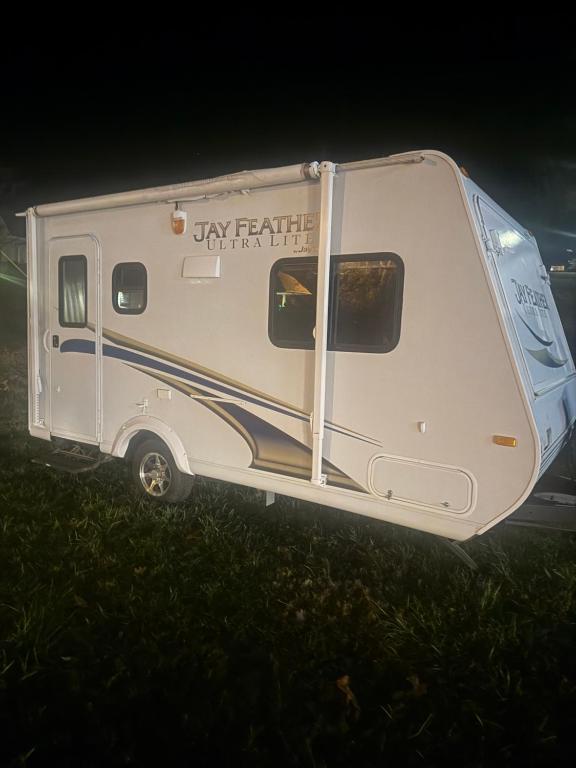 een witte camper 's nachts geparkeerd in het gras bij Ver-El RV Park & Campground in Concord