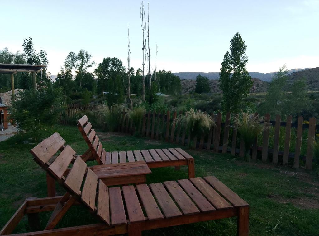 una panca di legno e un tavolo in un cortile di Cabañas Rowal Malbec Potrerillos a Potrerillos