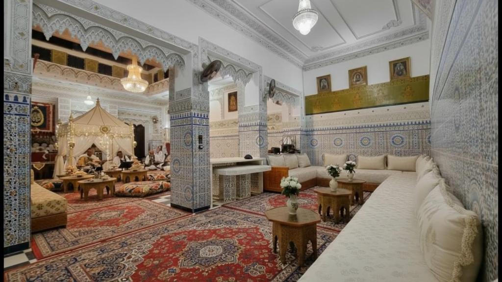 ein großes Wohnzimmer mit blauen und weißen Wänden in der Unterkunft Riad Imperial Atlas in Meknès