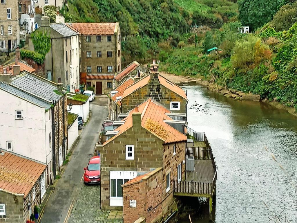 a group of buildings next to a river at Pilot Me Cottage in Staithes