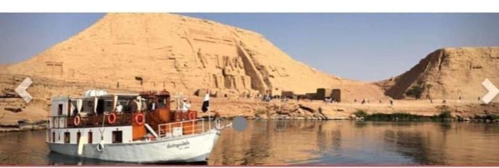 un bateau sur l'eau devant une pyramide dans l'établissement Dongolah Boat Abu Simbel, à Tunqālah