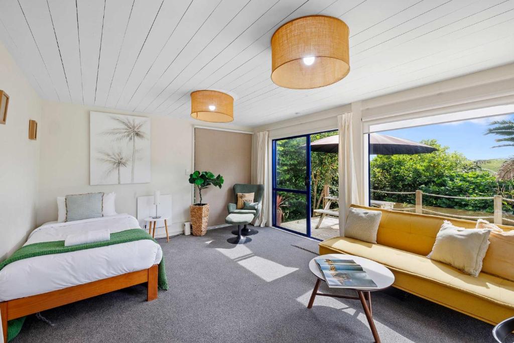 a bedroom with a bed and a couch at Butlers Studio Two in Oakura