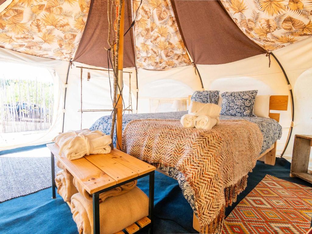 El RosarioLa Colmena Glamping Obrera的帐篷内的卧室,配有一张床和一张桌子