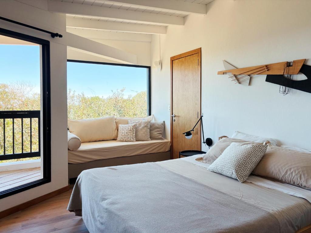 a bedroom with a bed and a large window at Casa Jacana in Maldonado