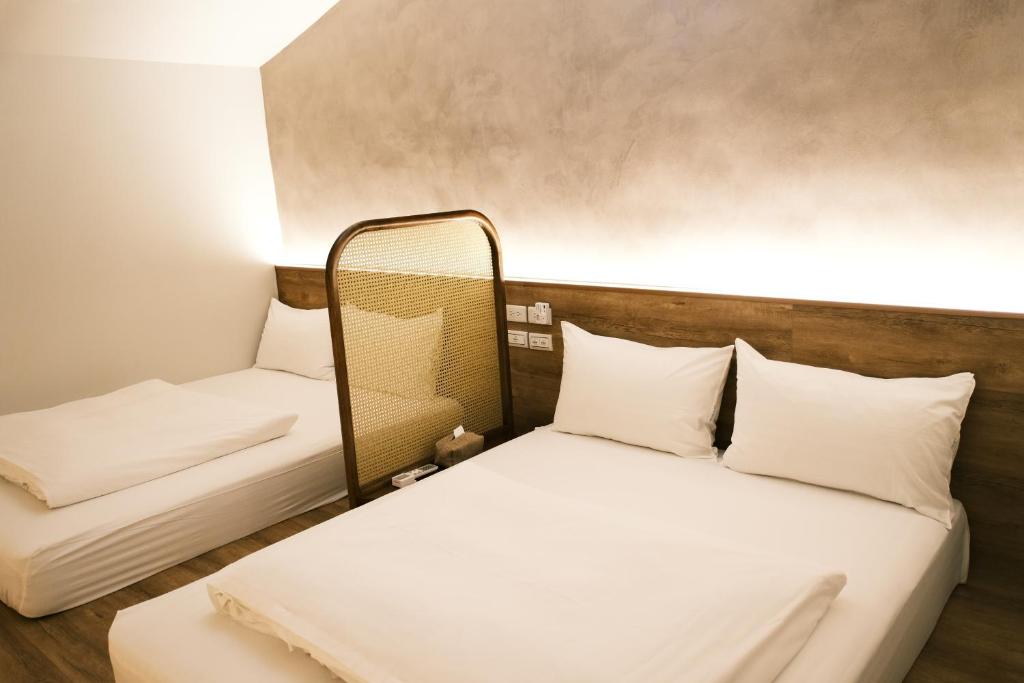 twee bedden in een kamer met een spiegel bij Cen Pin B&B in Jiufen