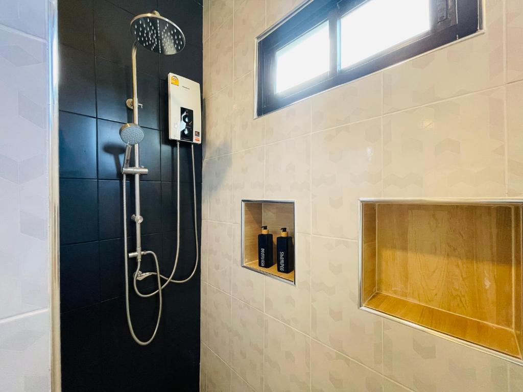 a shower with a shower head in a bathroom at Baan Sangchan in Ko Kood