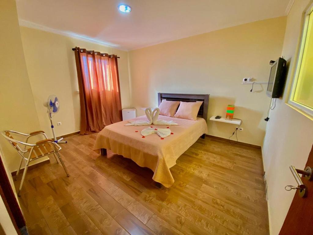 una camera da letto con un letto e una televisione di African Guesthouse a Tarrafal