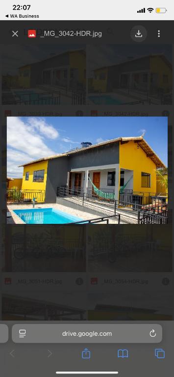 a picture of a house with a pool in front of it at Casa amarela in Santana do Riacho