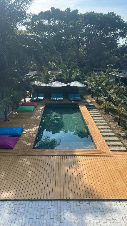 a swimming pool with benches and umbrellas in a resort at AQUA Boutique Resort & Pool in Ko Phayam