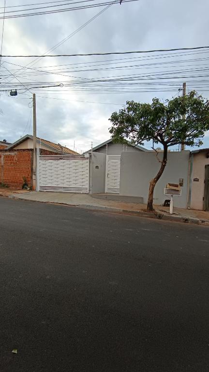 a building with a tree on the side of a street at Casatemporadapadilha in Olímpia