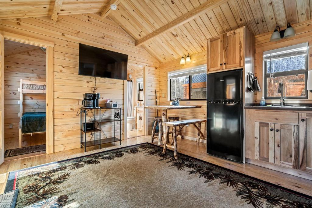 a kitchen with wooden walls and a black refrigerator at Cozy ski cabin #3, 3 beds in Bethel