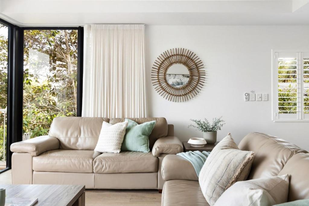 un salon avec un canapé et un miroir dans l'établissement Salty Stays on Stevens St Ocean Views Top Deck, à Sunshine Beach