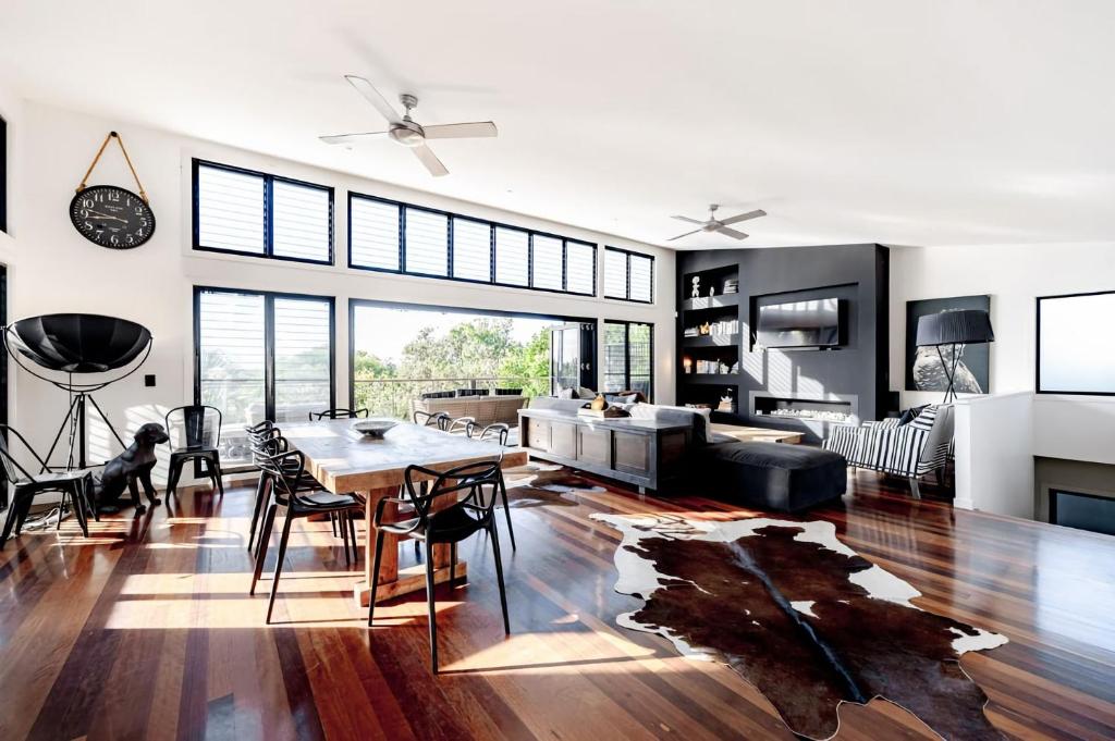 een woonkamer met een eettafel en een woonkamer met een bank bij Absolute Beachfront House with Pool & Views in Marcus Beach