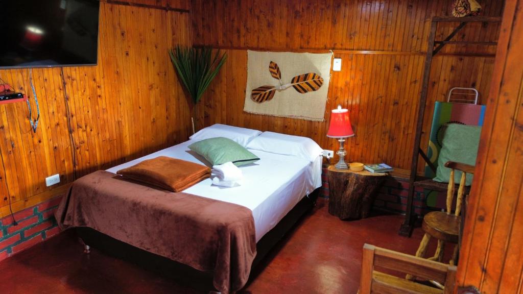 a bedroom with a bed in a wooden room at Tesorito House en las Montañas del Quindío in Filandia