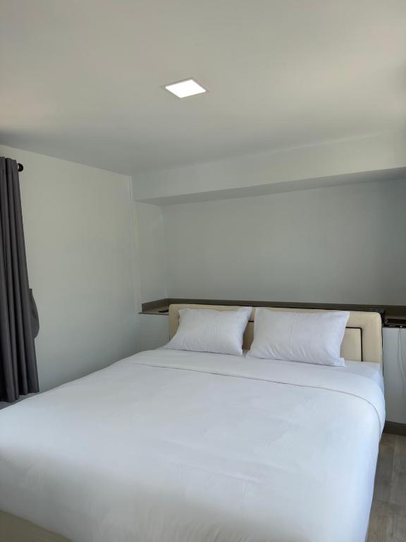 a bedroom with a white bed with two pillows at Siriwan boutique hotel in Ban Met Nang Chi