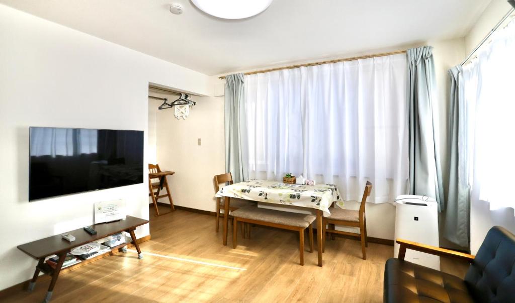 a living room with a dining room table and a television at Dream Tree 札幌市电步行0分钟 超市步行1分钟 in Sapporo