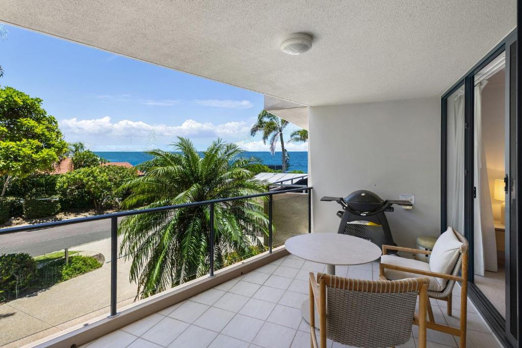 a balcony with a table and chairs and a view of the ocean at Unit 3 21 Park Generous and Comfortable Beachside Abode in Sunshine Beach