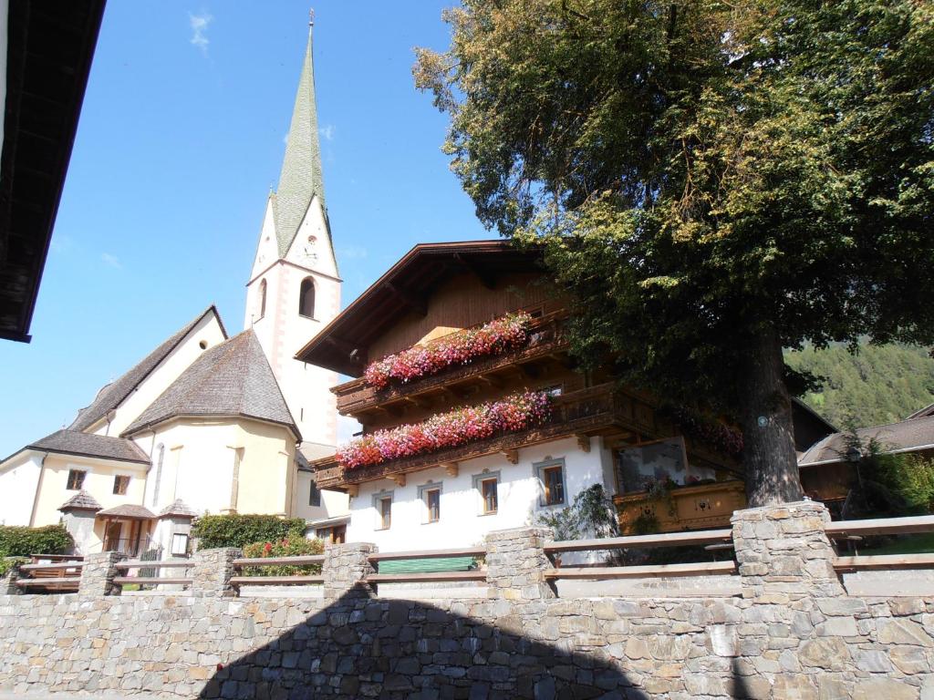 eine Kirche mit einem Kirchturm mit Blumen auf einem Gebäude in der Unterkunft Mesnerhof Virgen in Virgen