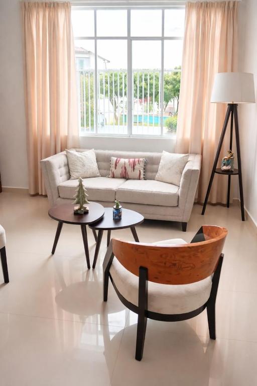 ein Wohnzimmer mit einer Couch und zwei Tischen in der Unterkunft Amplio departamento en Ica in Ica