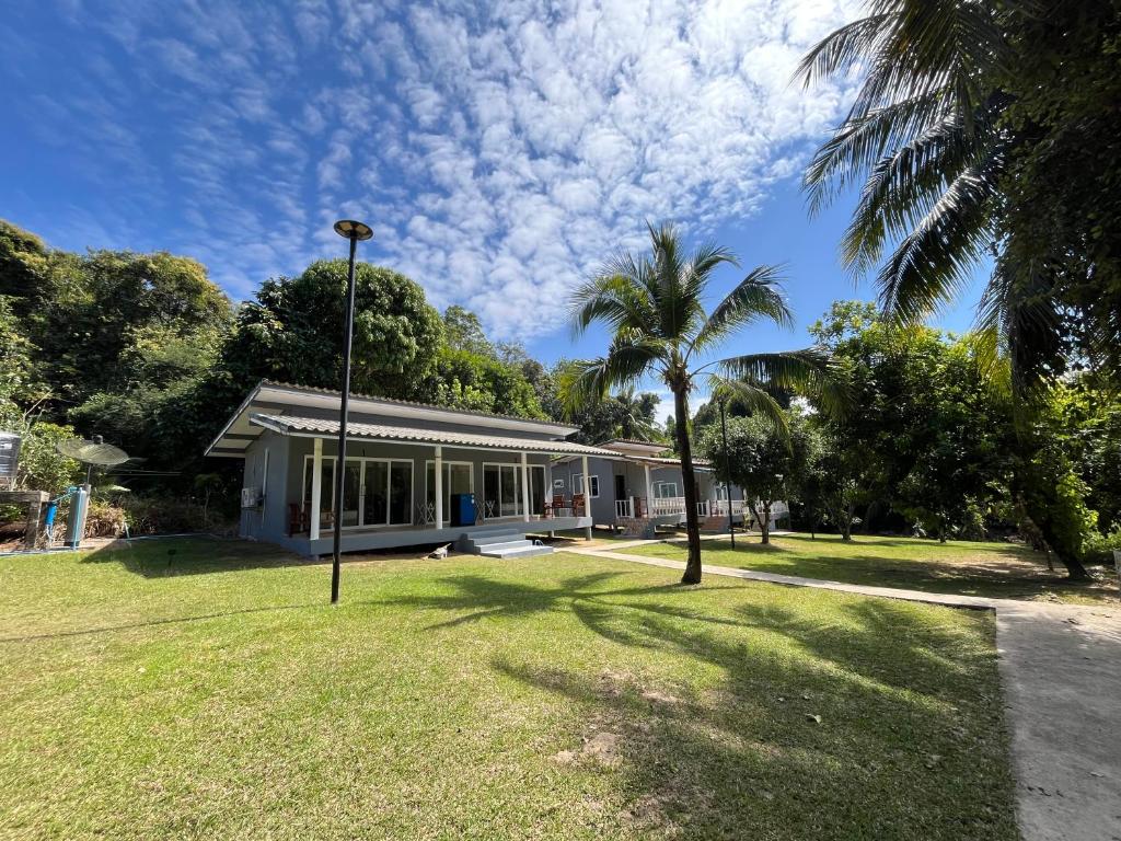 ein Haus mit einer Palme davor in der Unterkunft Ban Supattra in Ban Khlong Mat