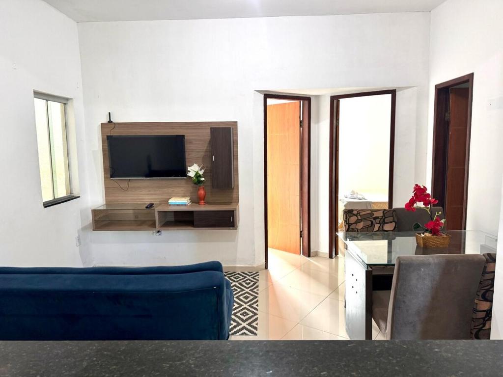 维多利亚-达孔基斯塔Aconchego Smart - Perto de tudo!的客厅里有一张蓝色沙发和一台电视