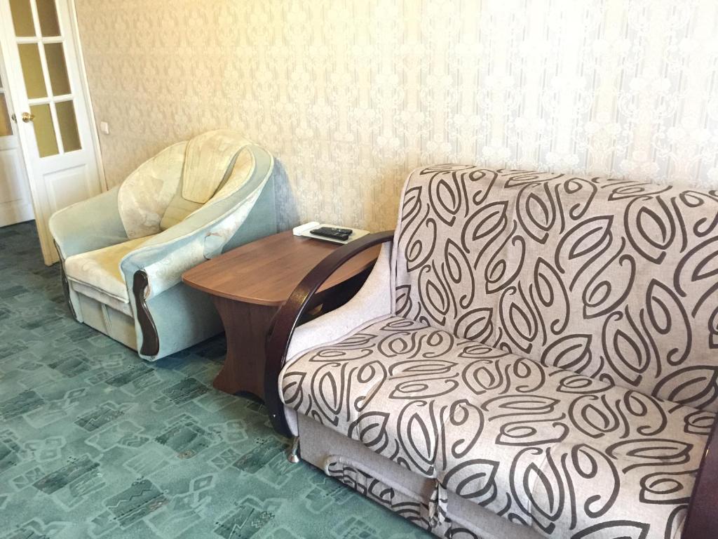ウフタにあるApartment On Oktyabrskaya 34のリビングルーム(椅子、テーブル付)