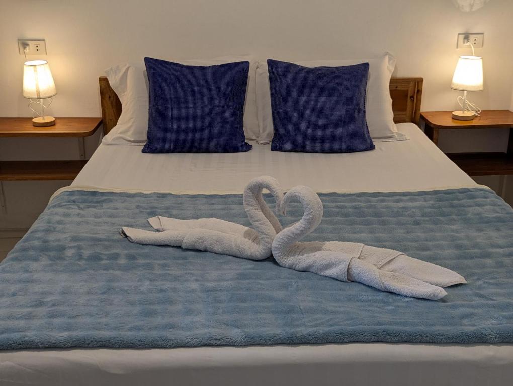 zwei Schwäne aus Handtüchern auf einem Bett in der Unterkunft Astillo's Guest Houses in Moalboal