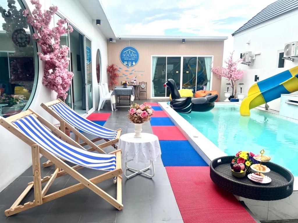 a pool with two chairs and a pool slide at Sea Fan Cha-am Pool Villa in Ban Bo Prakhon