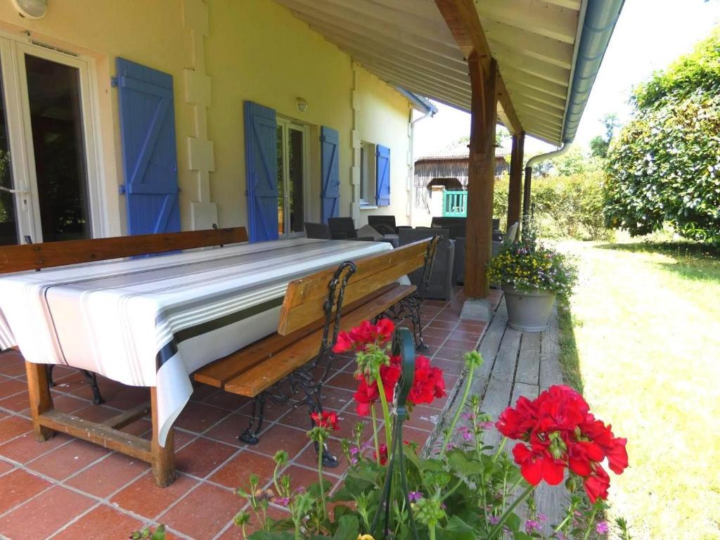 a white piano sitting on a porch with flowers at Gite de lescurade in Escource