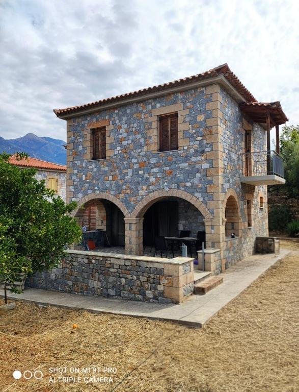a large stone house with a large patio at Galini Stone House in Proástion