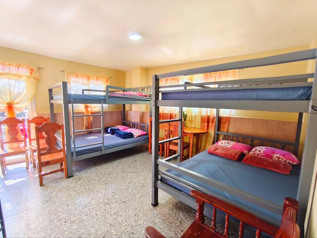 a room with three bunk beds and a table at Baguio Staycation with Mountain View in La Trinidad