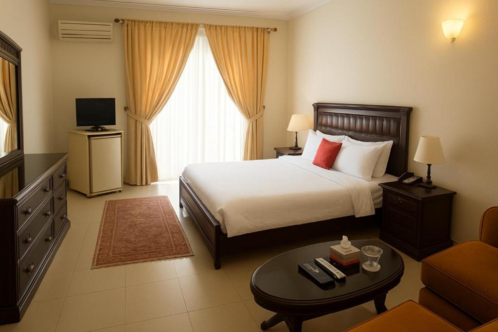 イスラマバードにあるHill Town Hotel Islamabadのベッドとソファのあるホテルの部屋