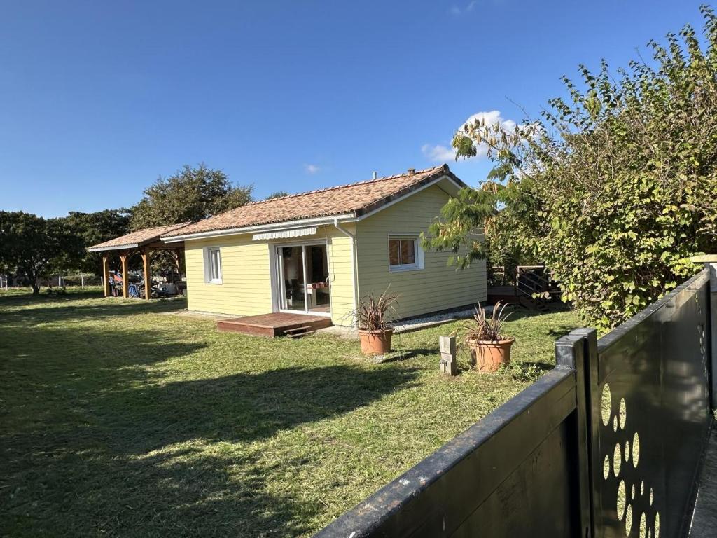 a small yellow house in a yard with a fence at Prejean in Léon