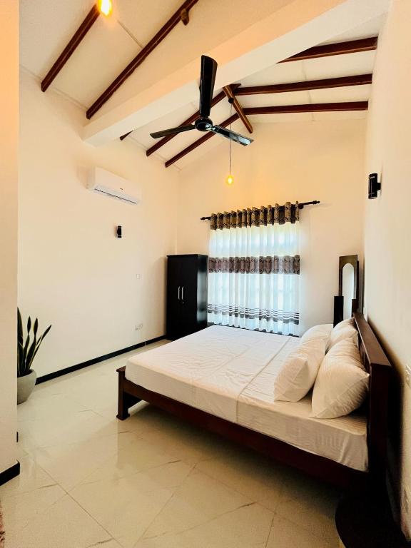 a bedroom with a bed and a ceiling fan at Green Hill Villa Thalpe in Talpe