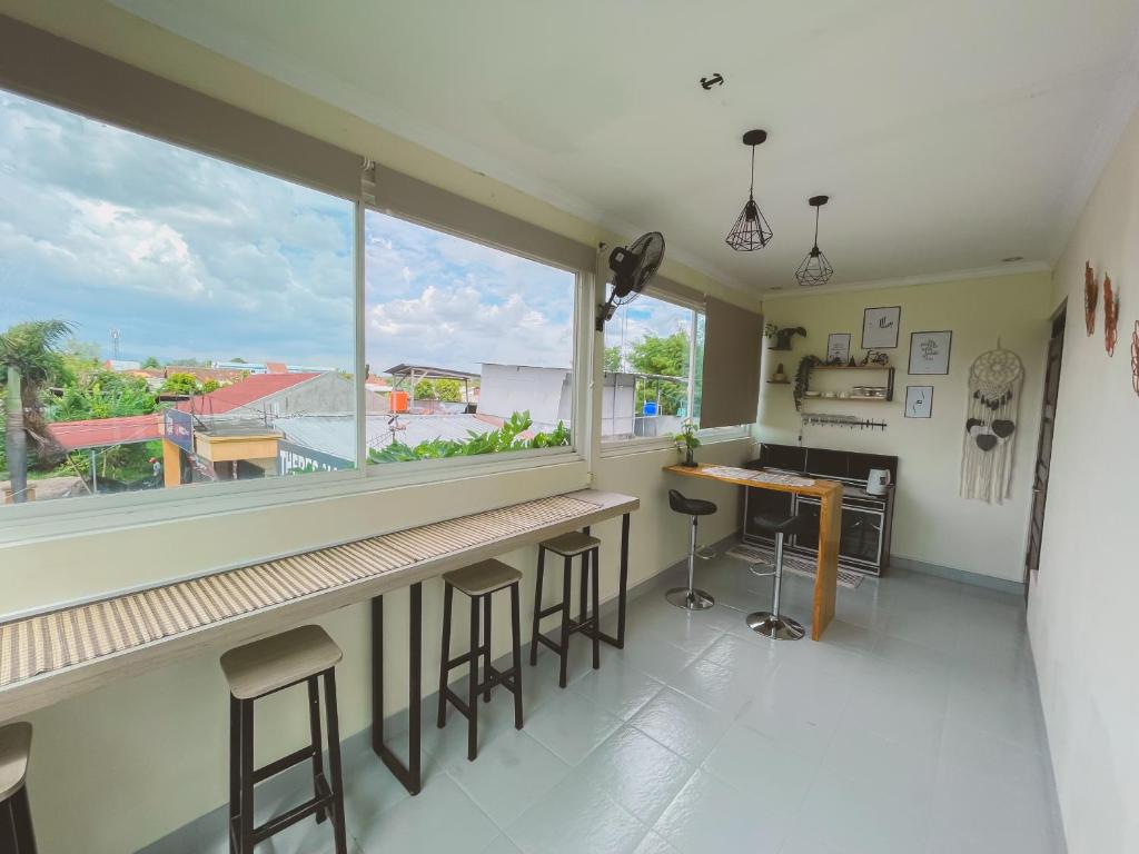 a kitchen with a large window and a counter with stools at Avana Guesthouse in Kalasan