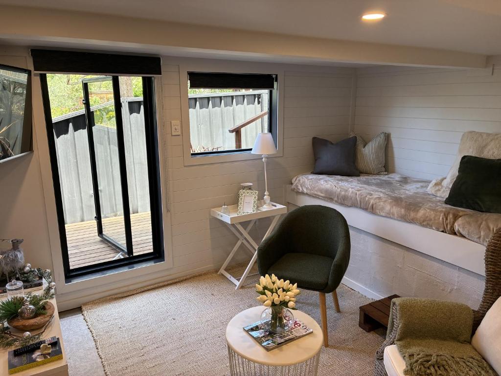 een woonkamer met een bank en een tafel bij Courtyard Pool Studio Private Luxe Retreat in Coal Point