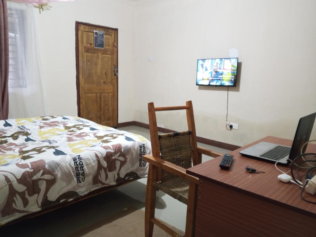 a bedroom with a bed and a desk with a laptop at Casa Havilah Inn in Chanamo
