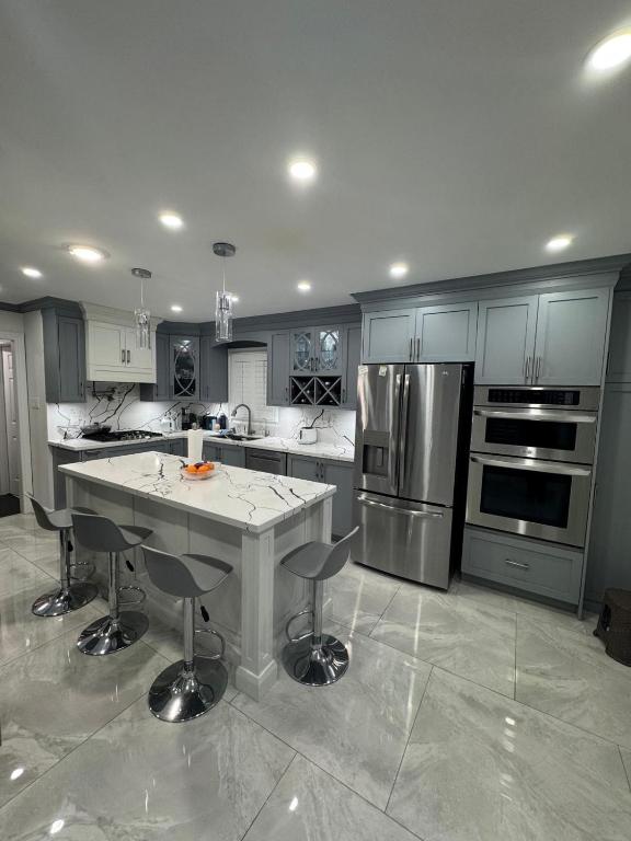 a large kitchen with a island in the middle of it at Pearson Gateway Comfort Home in Mississauga